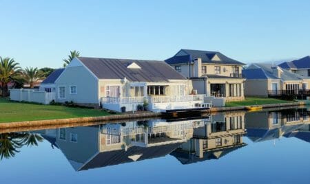 white single story houses beside body of water